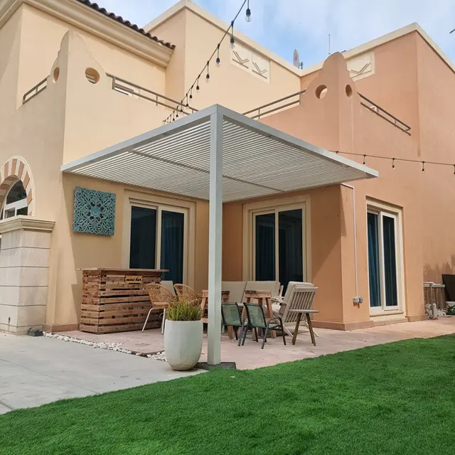 Modern slanted tube roof pergola providing permanent architectural shade for villa patio.