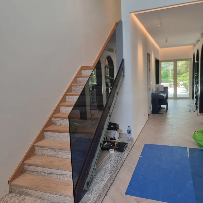 Luxury brown tinted glass stair railing providing a warm, bronze aesthetic for villa interiors.