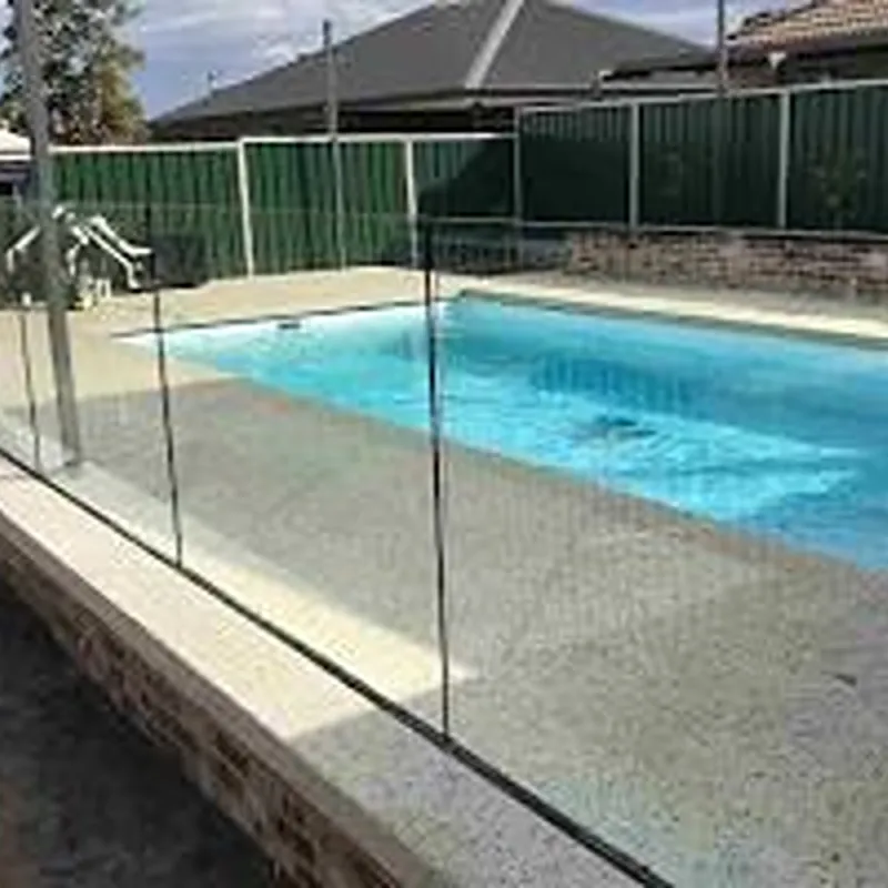 Minimalist pool glass fence using recessed aluminium U-channel for an invisible floor finish.