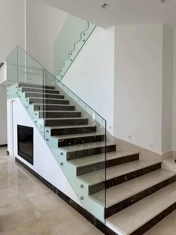 Modern frameless glass balustrade for indoor staircases with side-mounted glass pins.