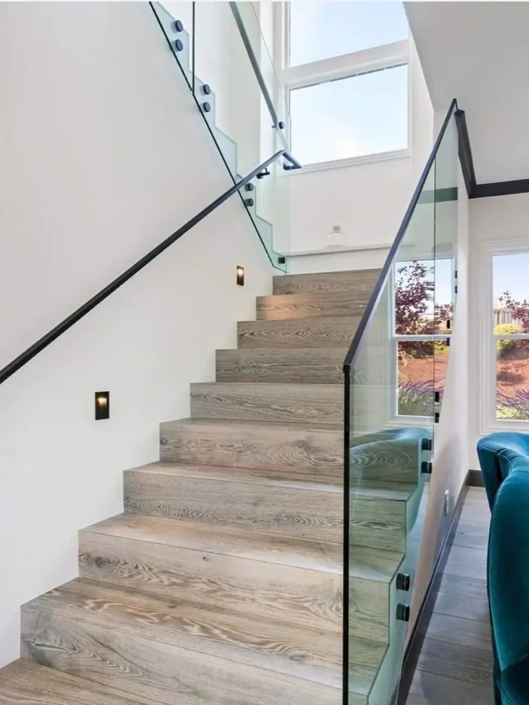 Modern frameless glass railing for staircases and balconies with top handrail.
