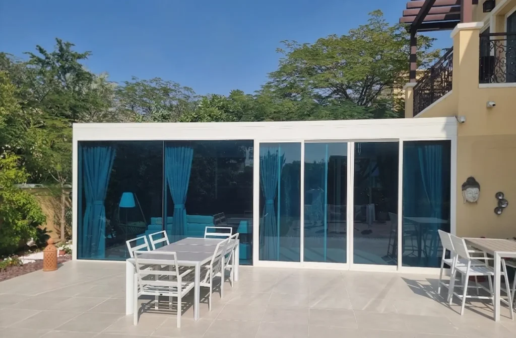 Full glass room extension with sliding aluminium doors for year-round garden views.