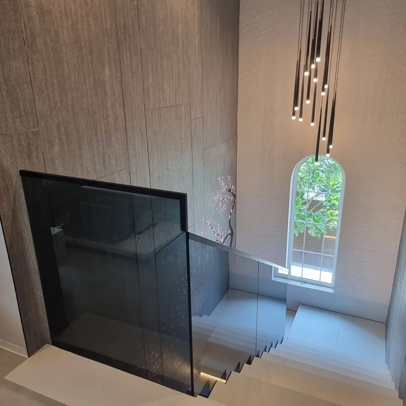 Smoked grey tinted glass railing for a modern, private look on commercial or residential stairs.