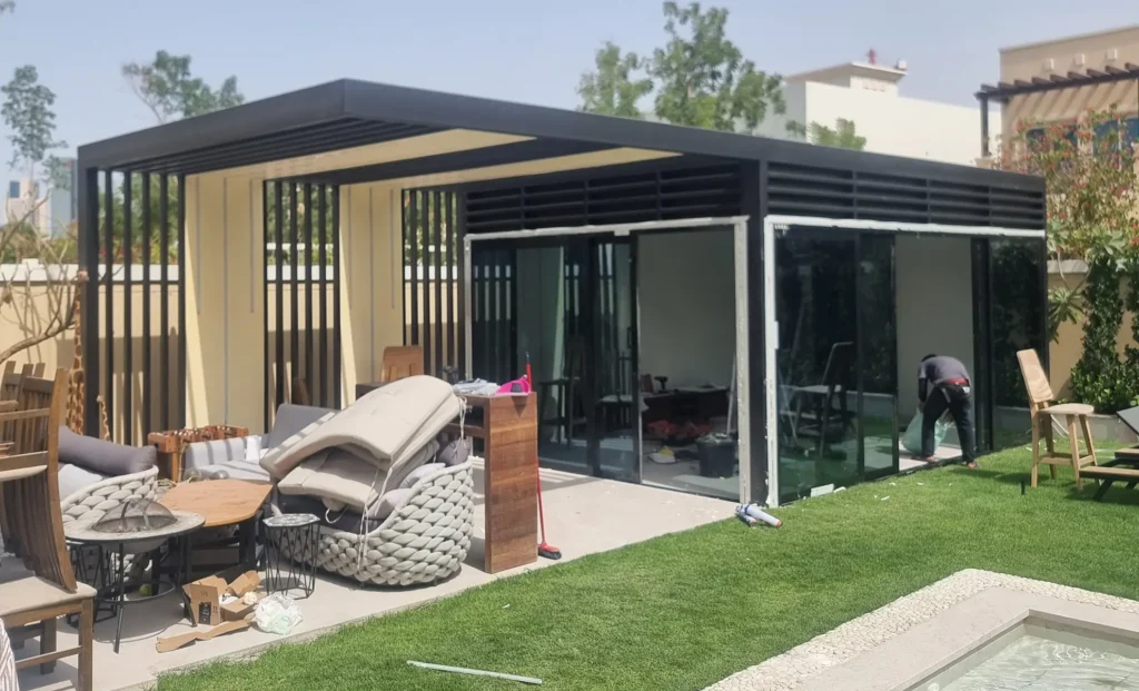 Custom glass room extension with slim aluminium frames and sliding doors for a villa garden.