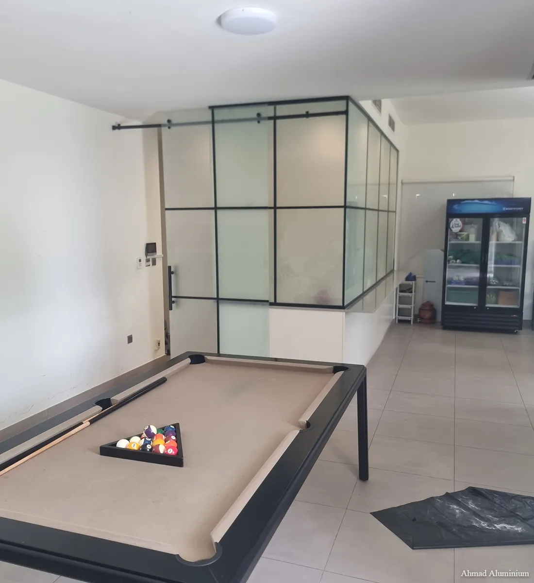 Frameless glass partition for modern kitchen and dining area in a Dubai villa.
