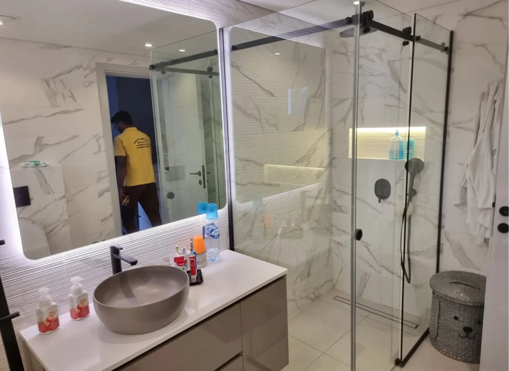 Space-saving sliding glass shower enclosure with smooth roller system and stainless steel handle.