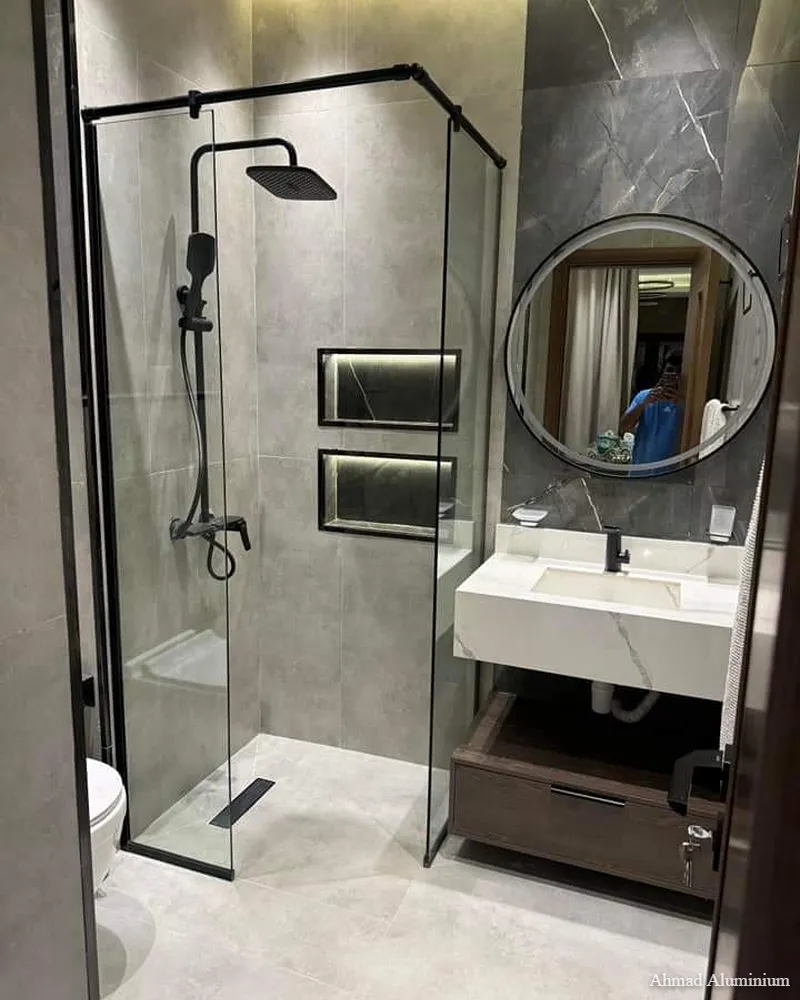 Walk-in fixed glass shower partition with floor-to-ceiling support bar.