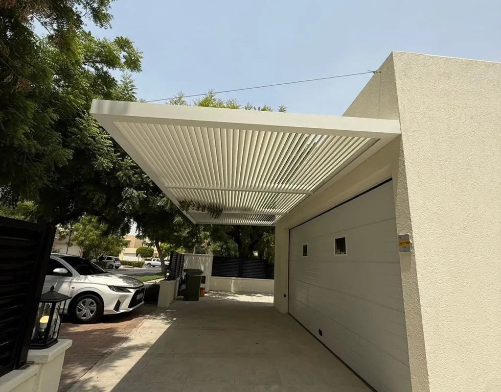 Heavy-duty wall-attached aluminium pergola providing shade for a terrace dining area.