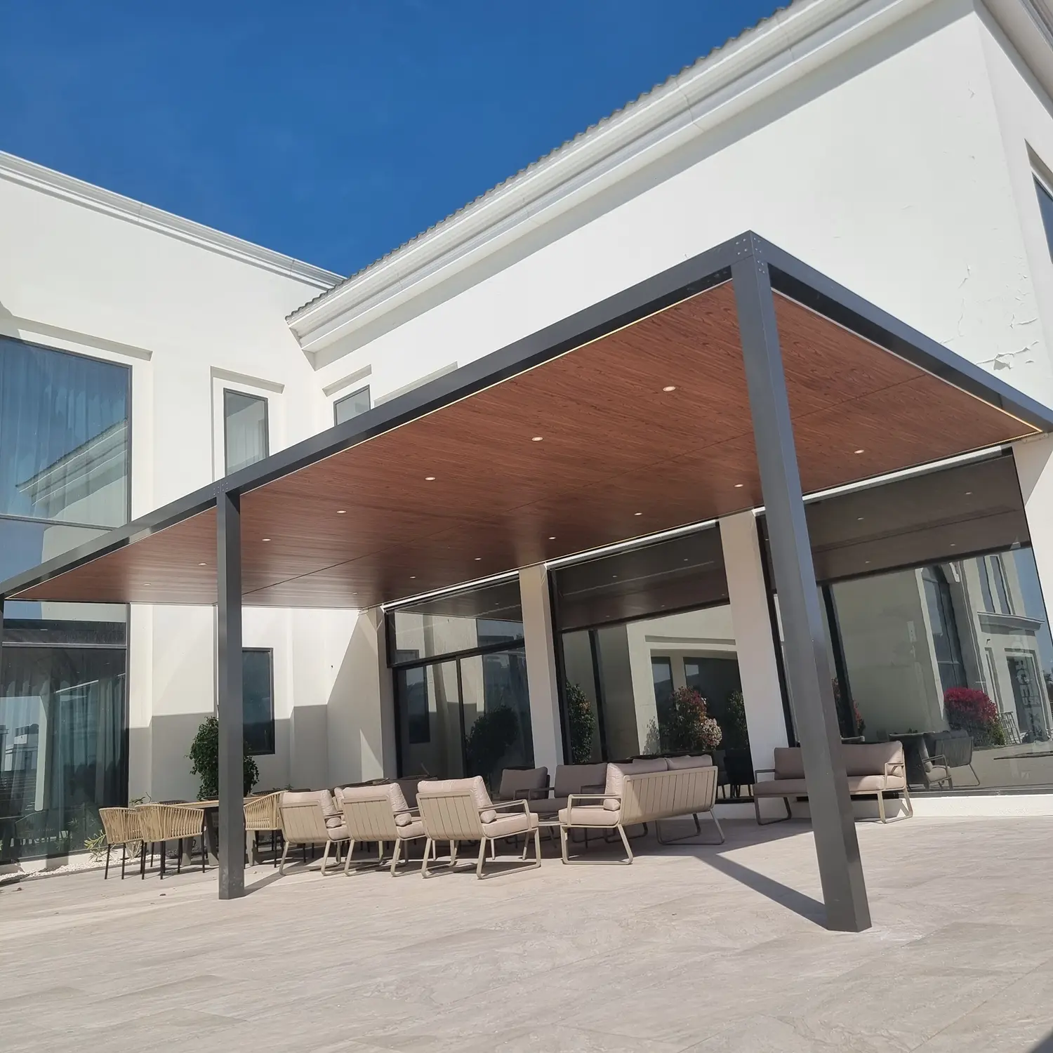 Durable aluminium pergola with a natural wood-grain powder-coated finish for a rustic look.