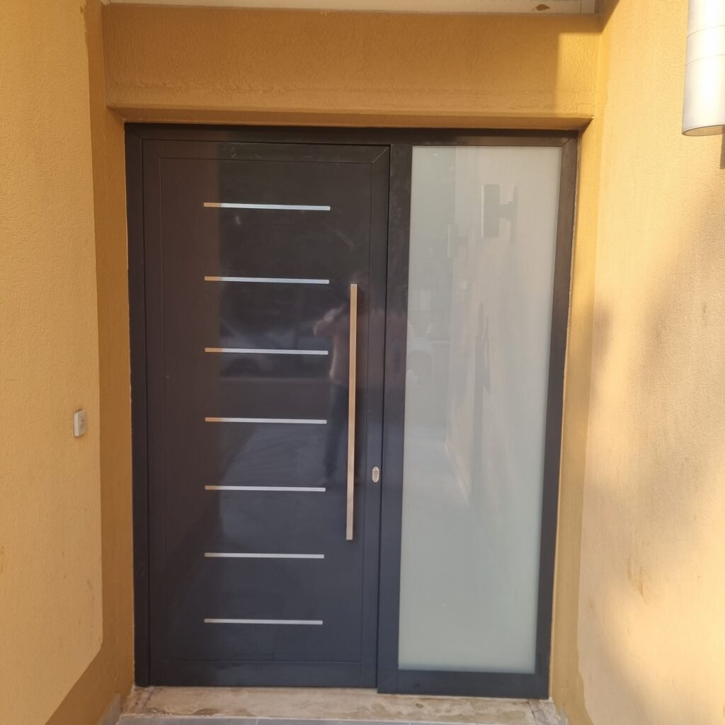 Contemporary sleek black aluminium main entrance door installation for a modern residential villa entrance