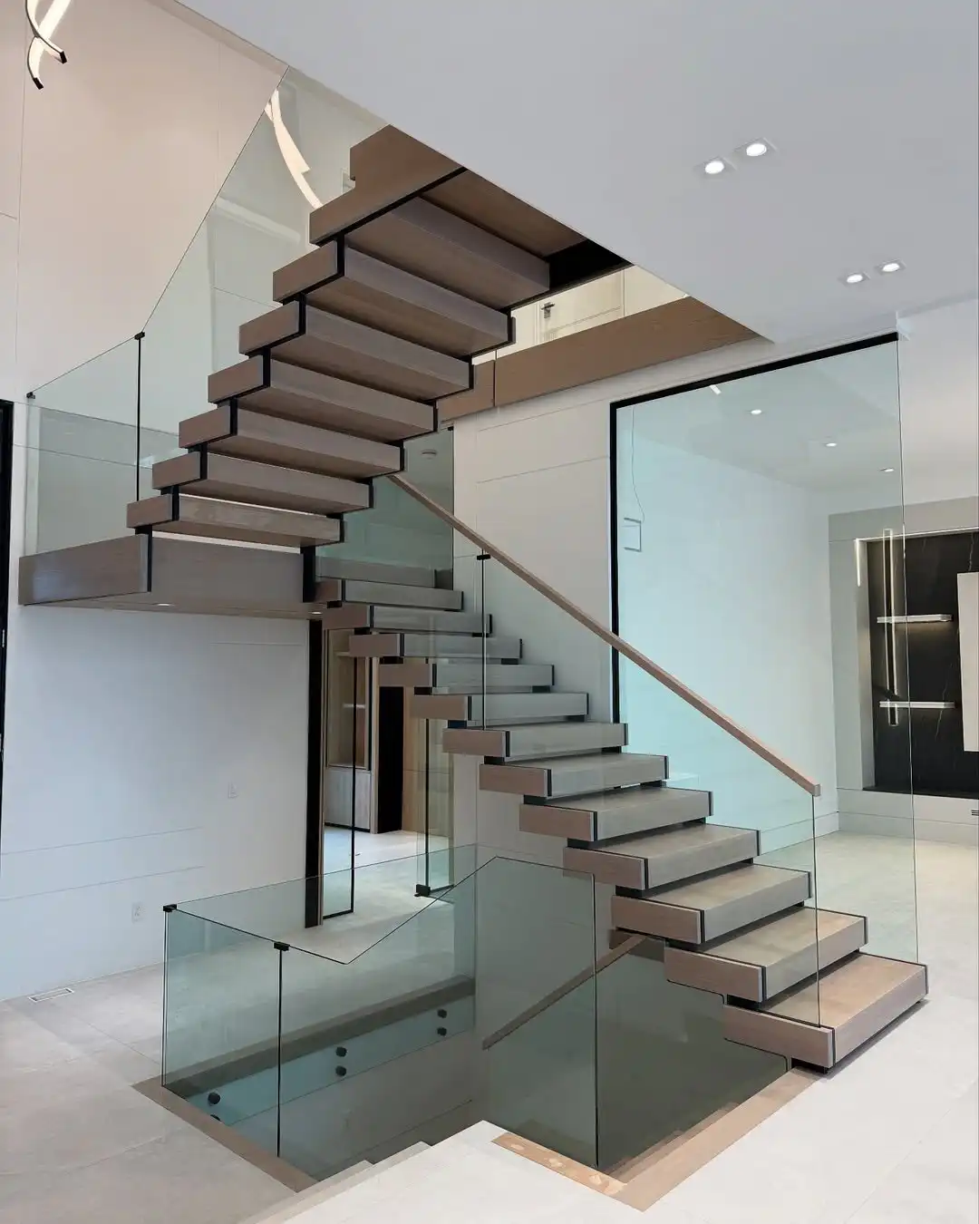Our luxurious glass railing features custom zigzag notched glass panels and a natural oak cap ra
